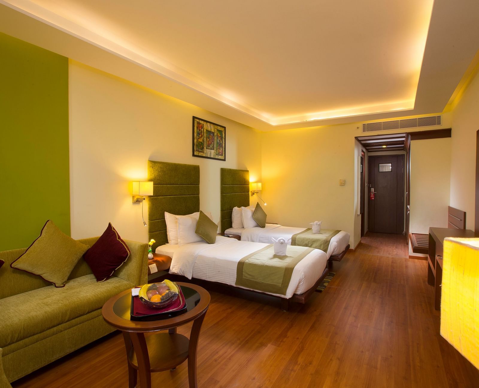 Superior Room featuring twin beds, sofa and a television at Hotel Atithi - TGI Grand, Pondicherry