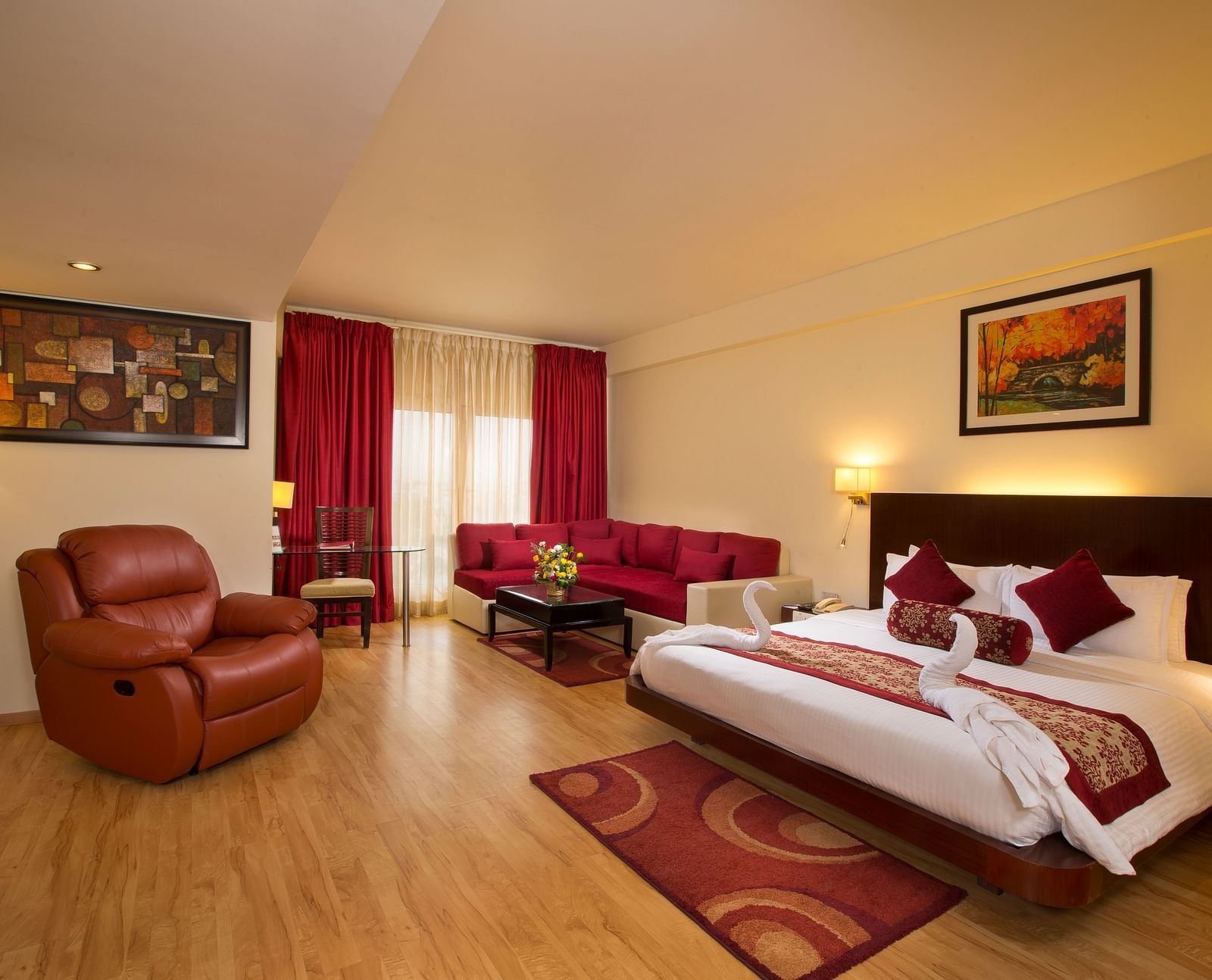Family Suite decked with a bed, a sofa and a recliner overlooking a window at Logo of Hotel Atithi - TGI Grand, Pondicherry