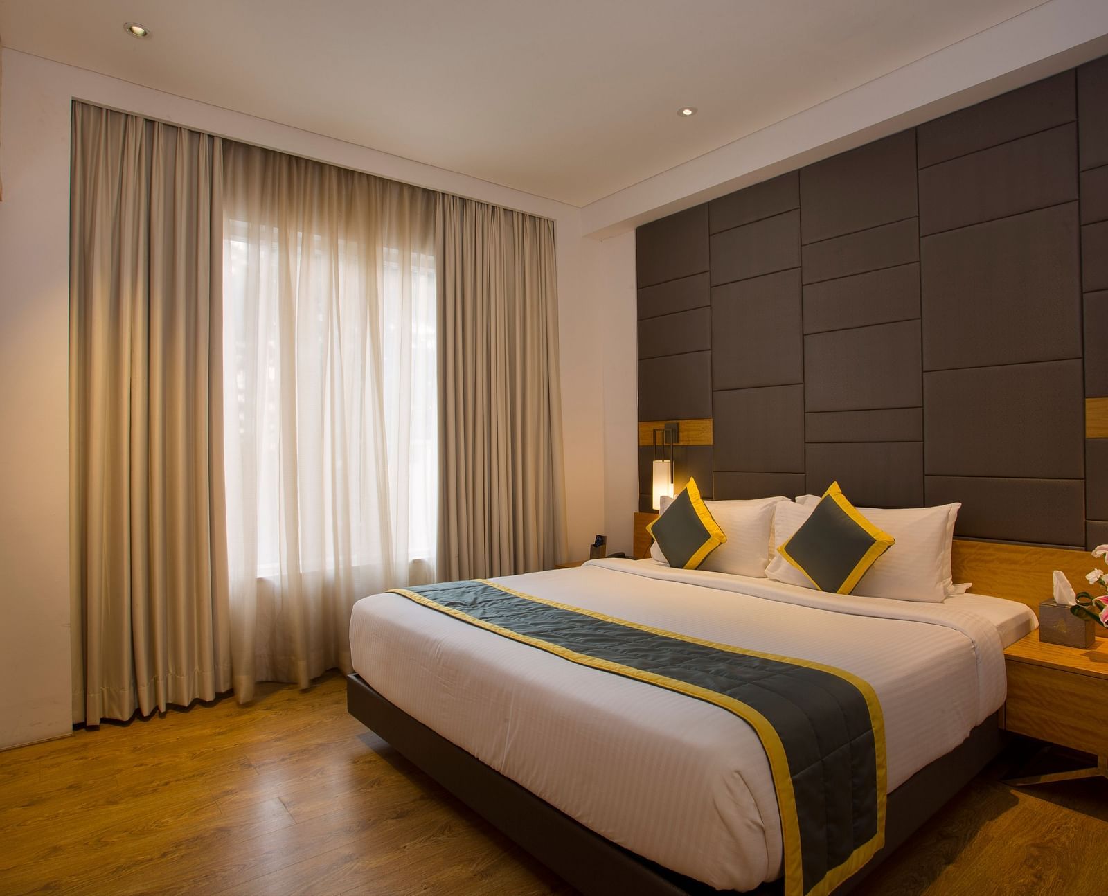 view of a bedroom with a large bed facing a television and two side drawers, one on each side of the bed - Hotel Fountain Tree By TGI - JP Nagar, Bangalore