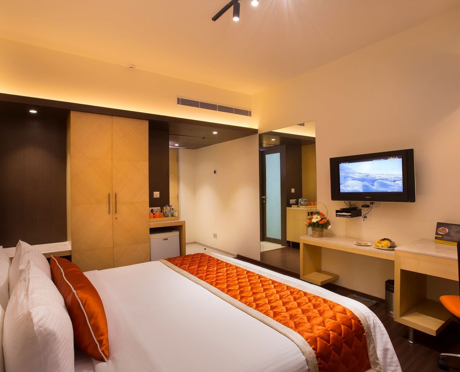 A comfortable hotel room with modern amenities, a large bed, a TV and a work desk with a chair - Hotel Langford Keys by TGI, Shanti Nagar