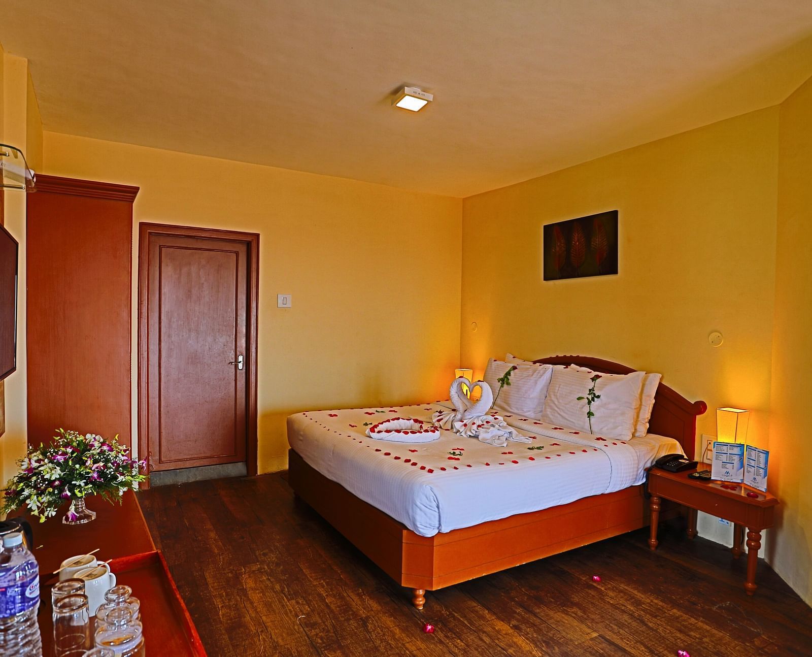 a plush white bed decked with flower petals at La Montana By TGI, Ooty
