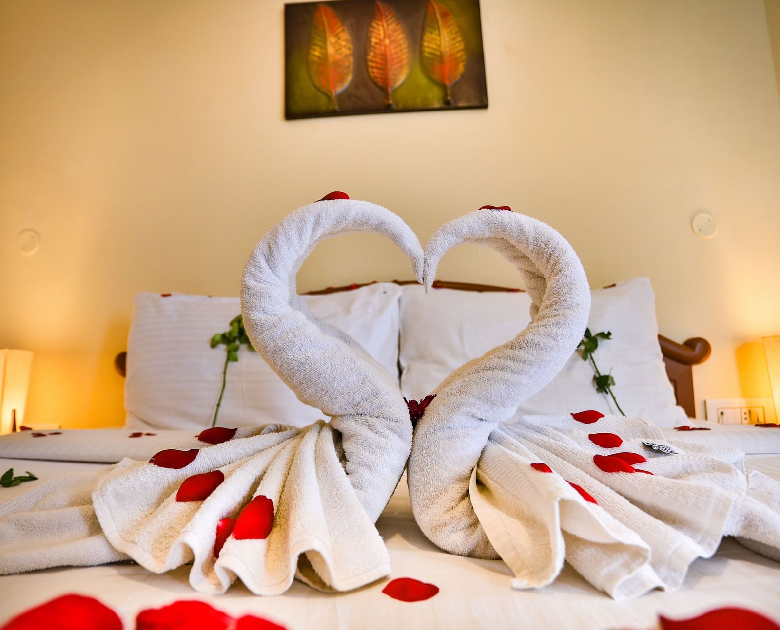 two swans made of towel are placed on a bed at La Montana By TGI, Ooty