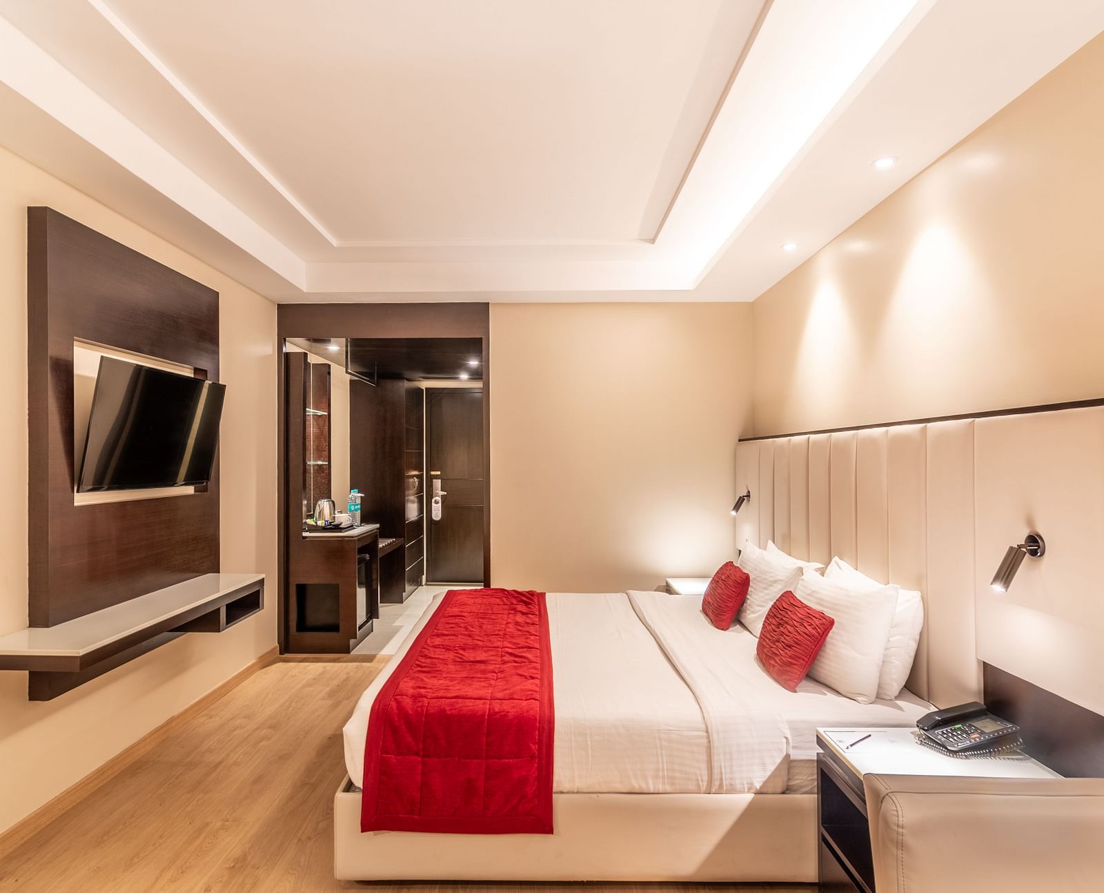 Bedroom with mounted TV, bedside lighting, and seating area- TGI Grand Fortuna, Krishnagiri Main Road, Hosur