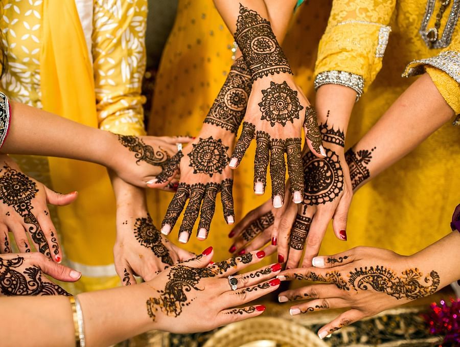 women showing their henna hands