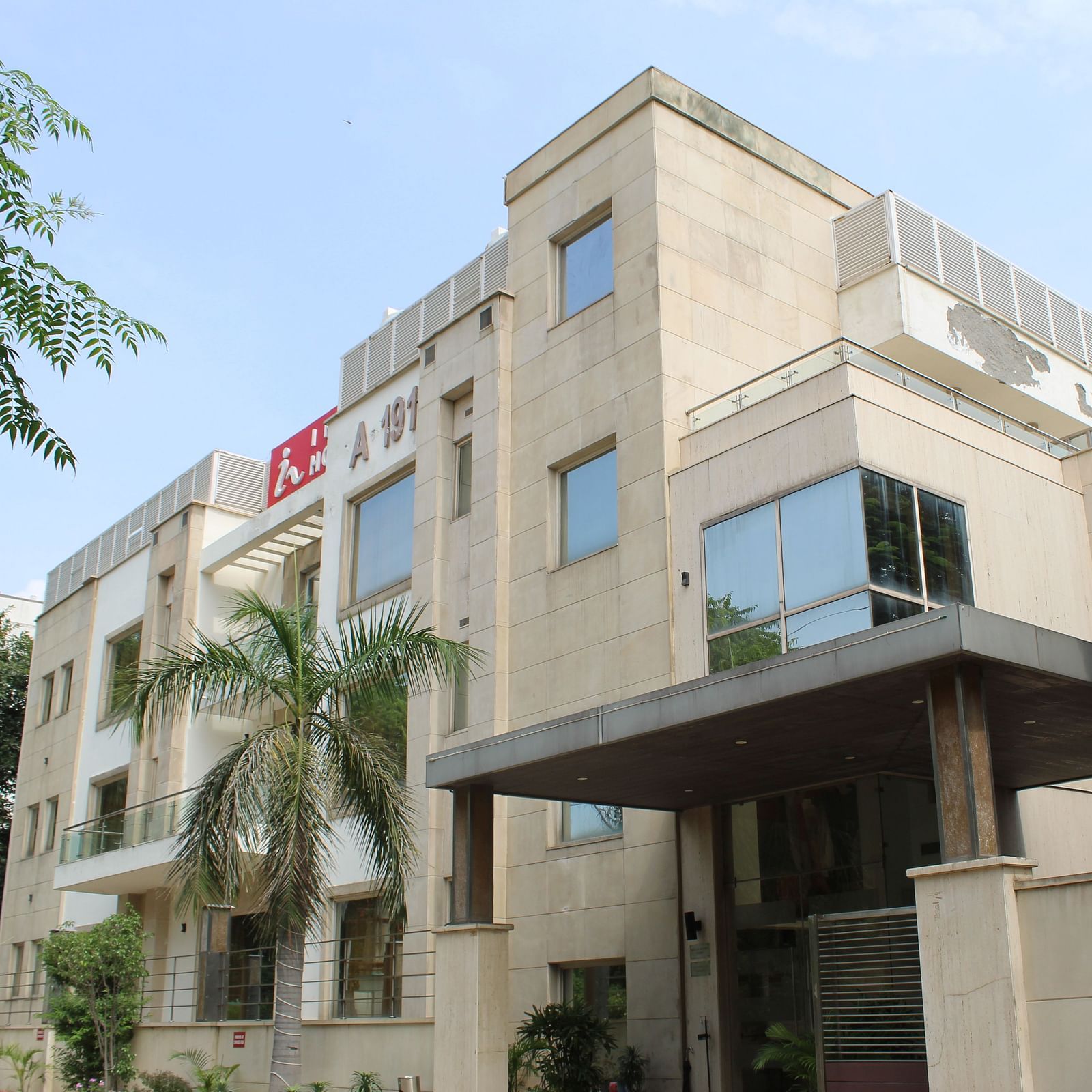 A facade image of Inde Hotels Vista Woods featuring a multi storey building surrounded by trees