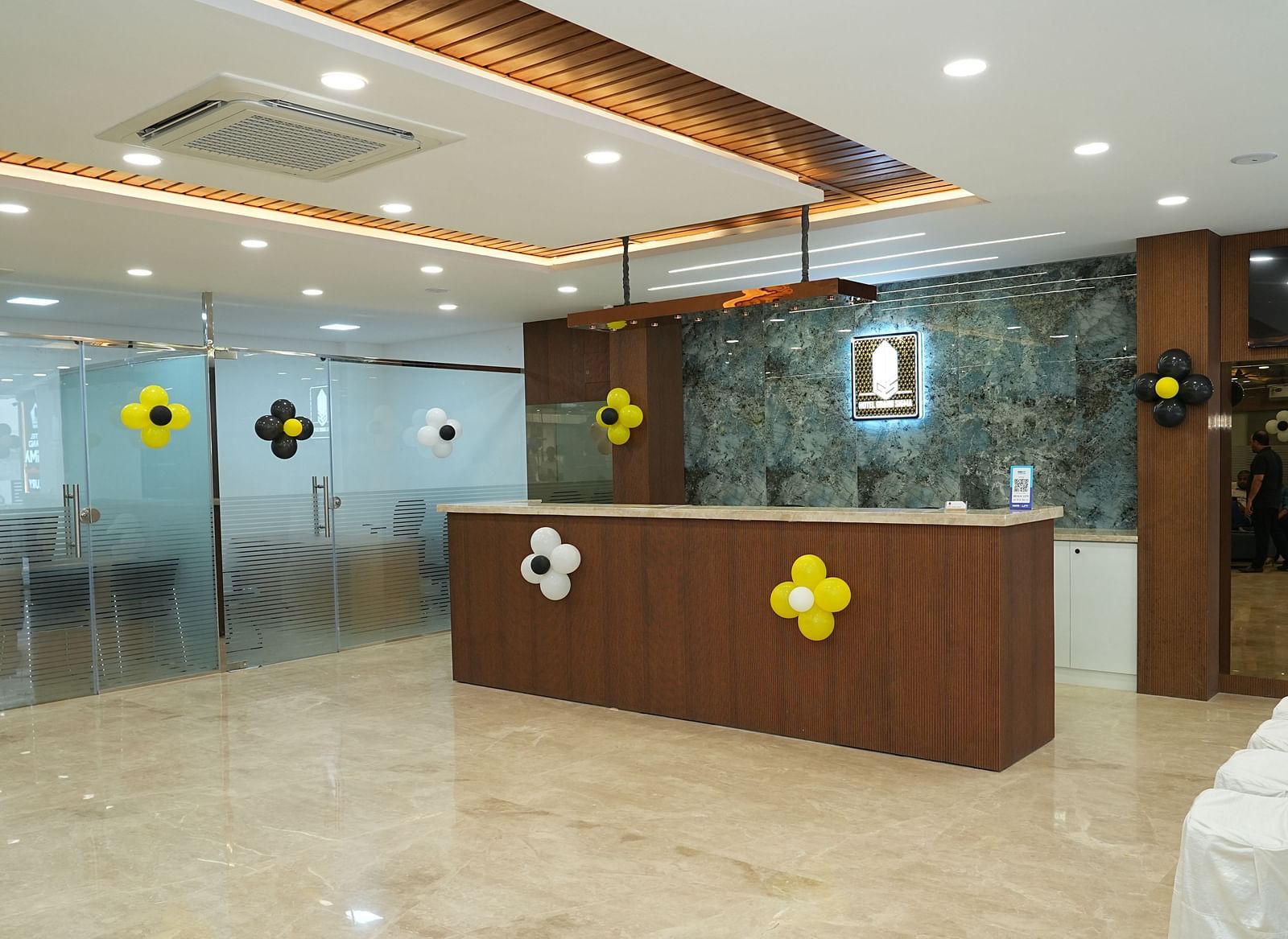 a wide angle shot of the reception area with a desk in the middle of the lobby - Hotel Grand Sigma