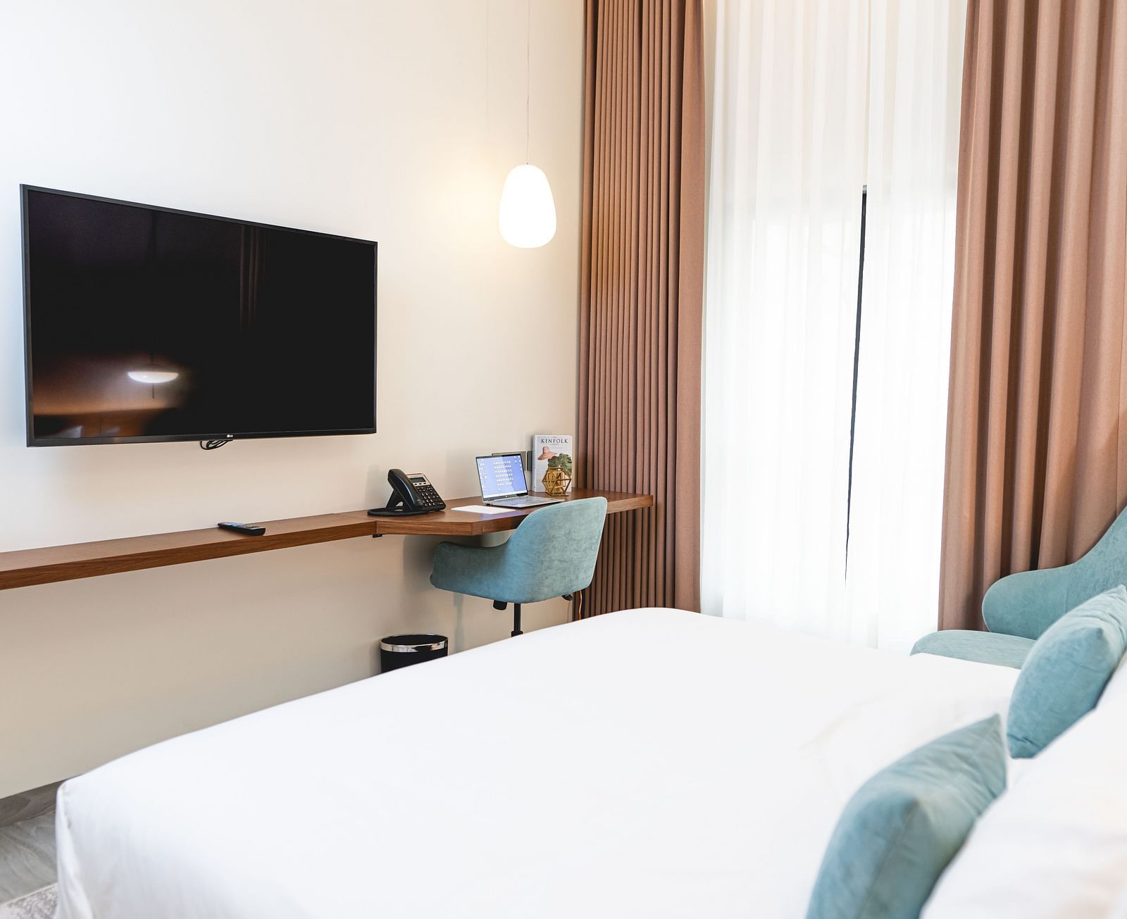 image of the standard room at Kertel Suites, kinshasa featuring a wall mounted television placed opposite to a double bed