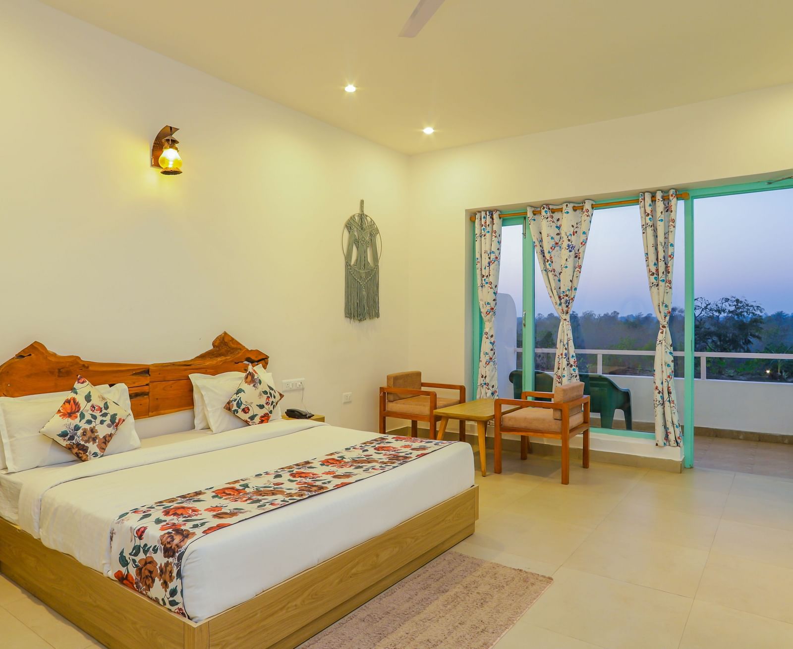 A cosy bedroom at Vedikant Resorts The Mallard Corbett includes a bed, chairs, and a view through the balcony.