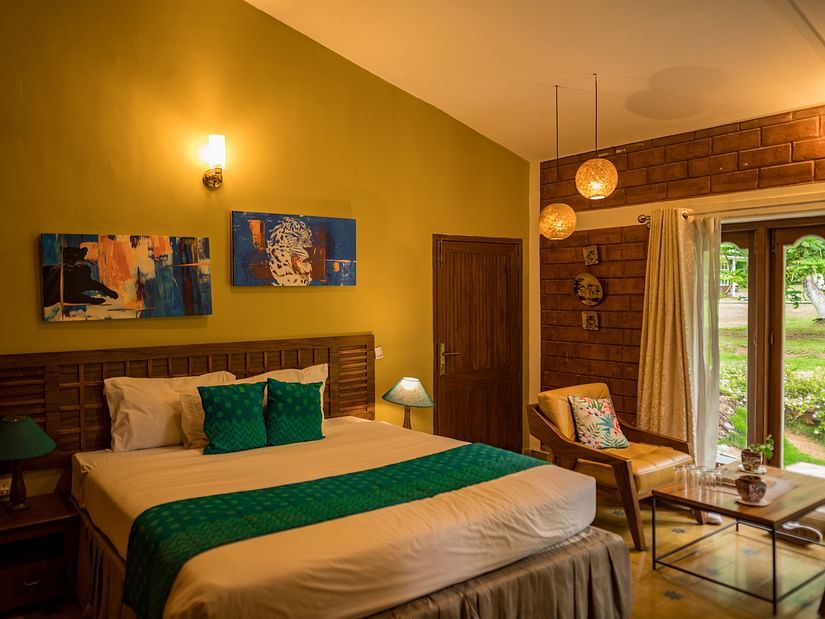 room with a comfy king size and big windows overlooking the garden