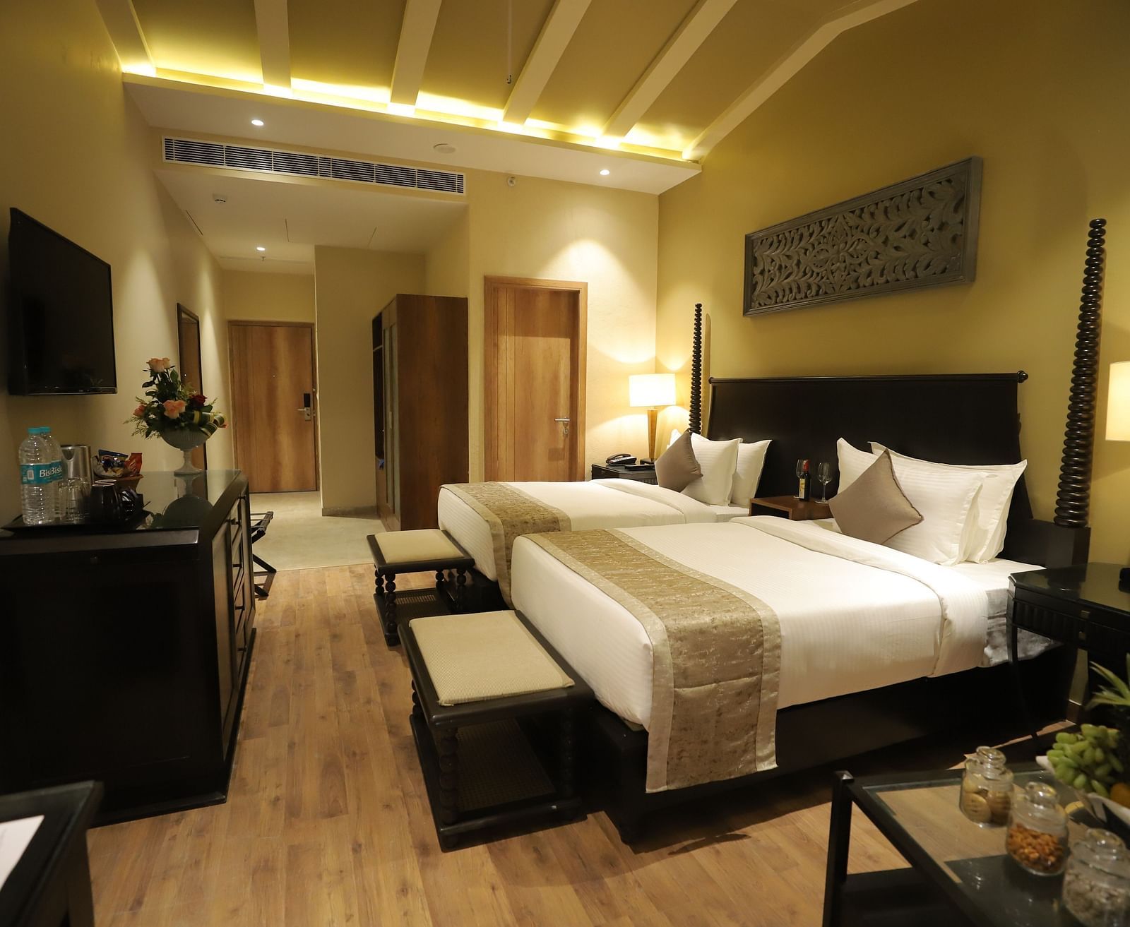 Studio Quad Room with double beds placed in front of TV at Essentia Luxury Resort & Spa, Udaipur.