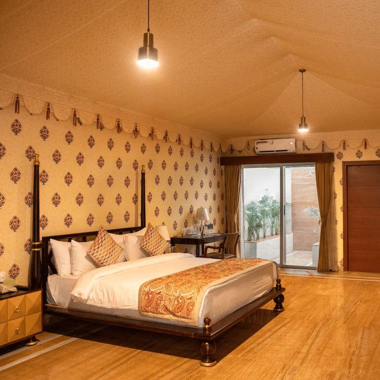 The interiors of our tent suites in Pushkar with a bed, a sofa set and tasteful decor 