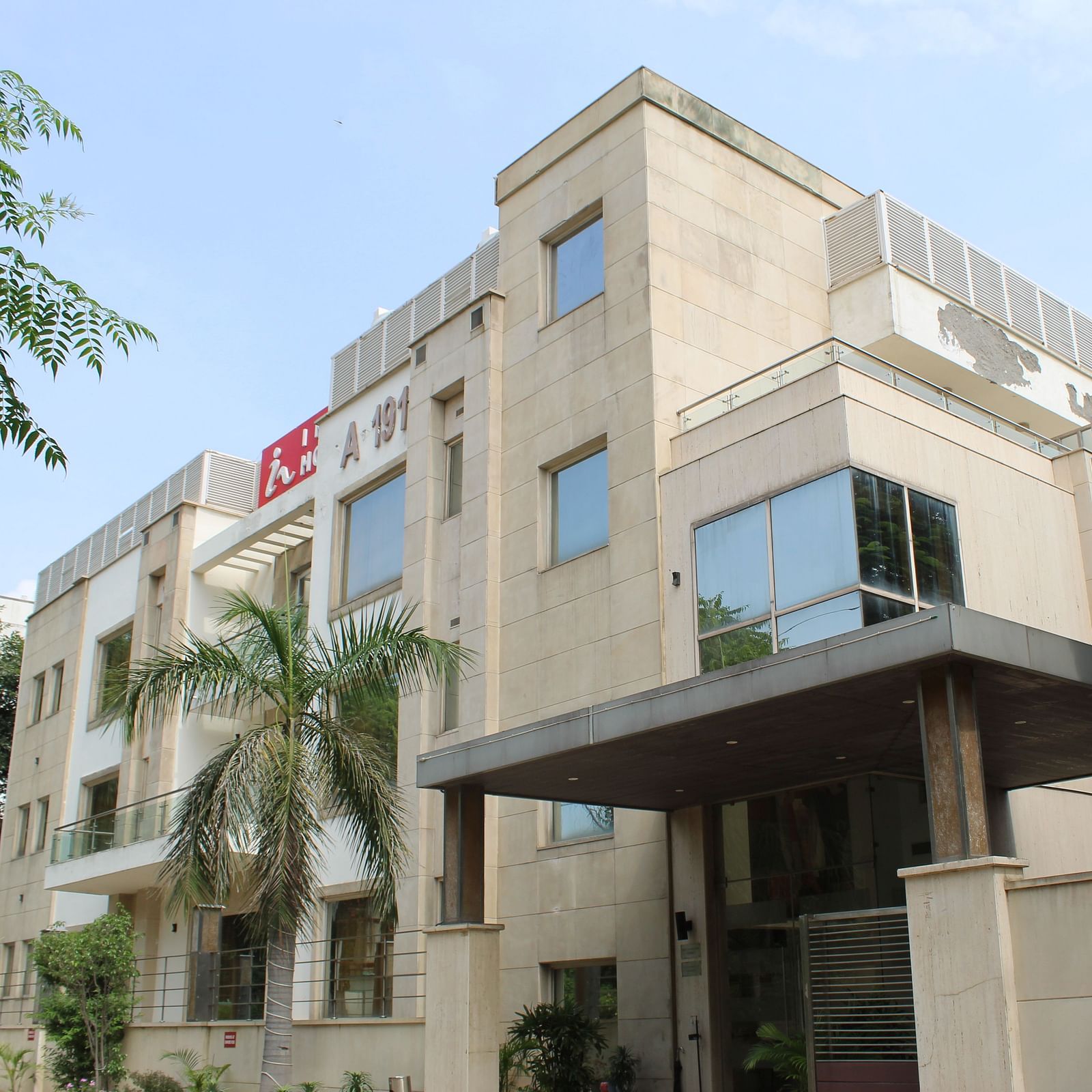 A facade image of Inde Hotels Vista Woods featuring a multi storey building surrounded by trees
