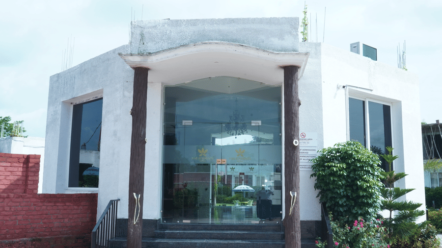 Exterior front entrance view of the hotel main building featuring large glass doors, steps, and surrounding landscape - Five Elements Hotels, Corbett Crown Resort, Jim Corbett