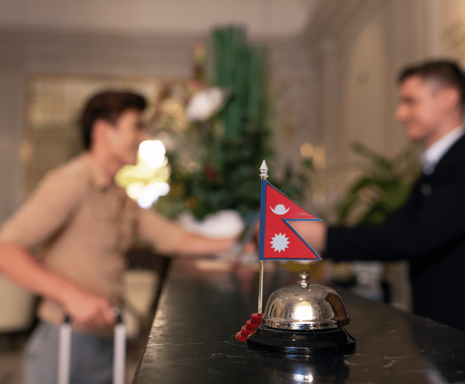 Receptionist greeting a guest in the desk which has Nepal flag | Kavya Resort and Spa, Nagarkot