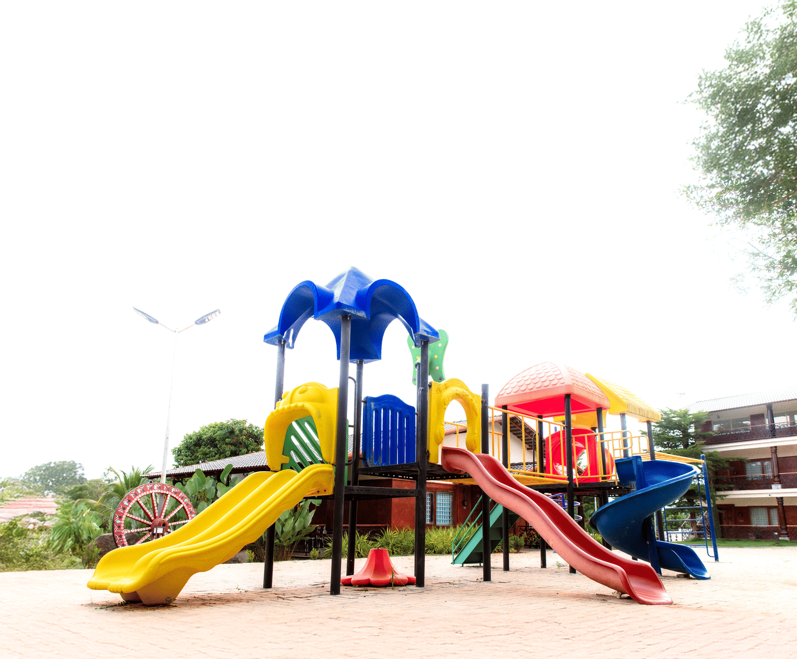A children's outdoor playground featuring multi-coloured slides and climbing frames on a sunny day | Vintage Trails By Ilara