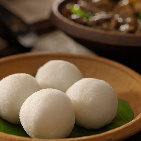 Four Coorg steamed rice balls (Kadamputtu) with curry.