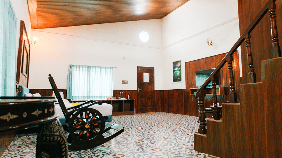 An indoor room with wooden panelling, a wooden staircase, and a decorative traditional carriage model | Vintage Trails By Ilara