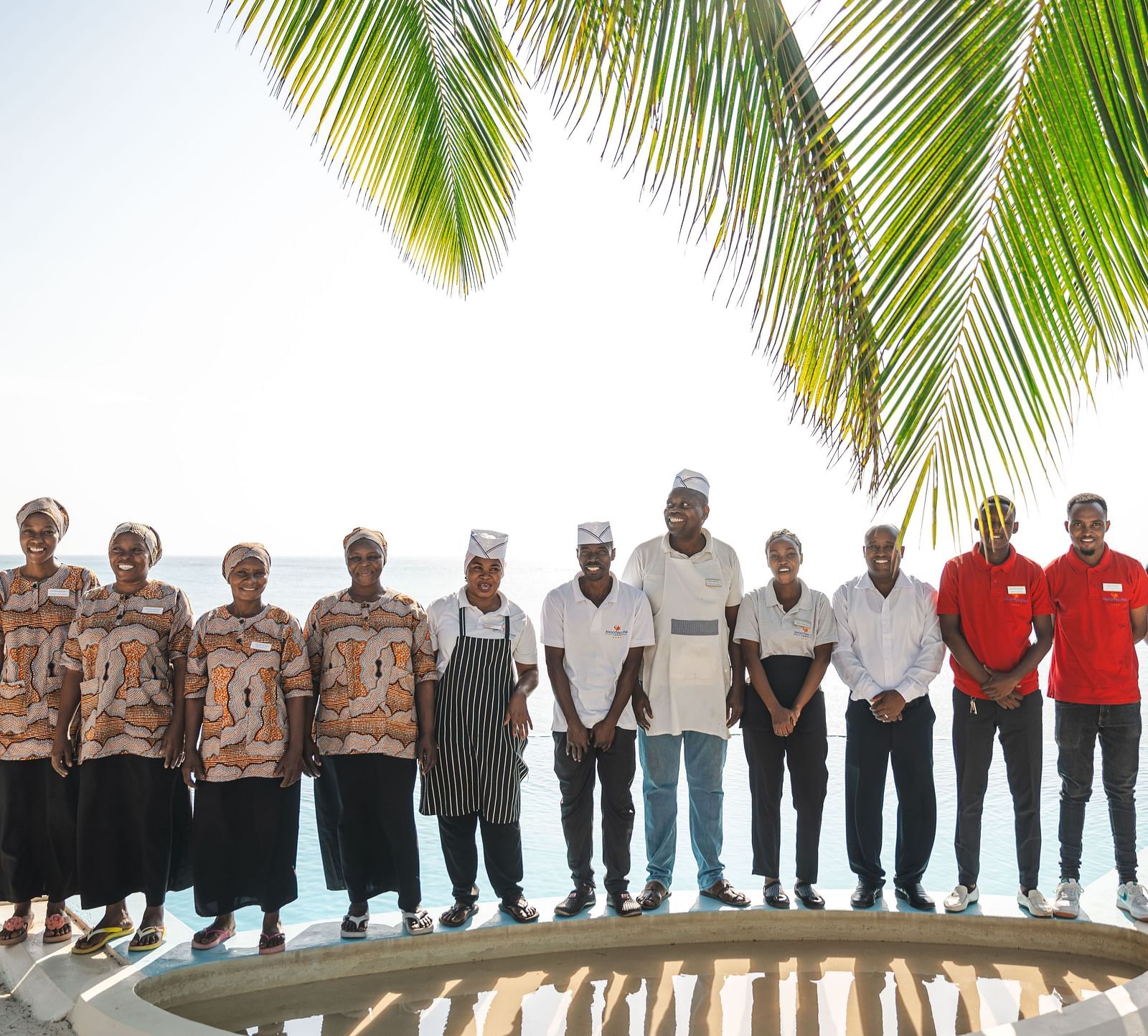 Staff members at shooting star Boutique Hotel posing for a group picture with swimming pool in the background