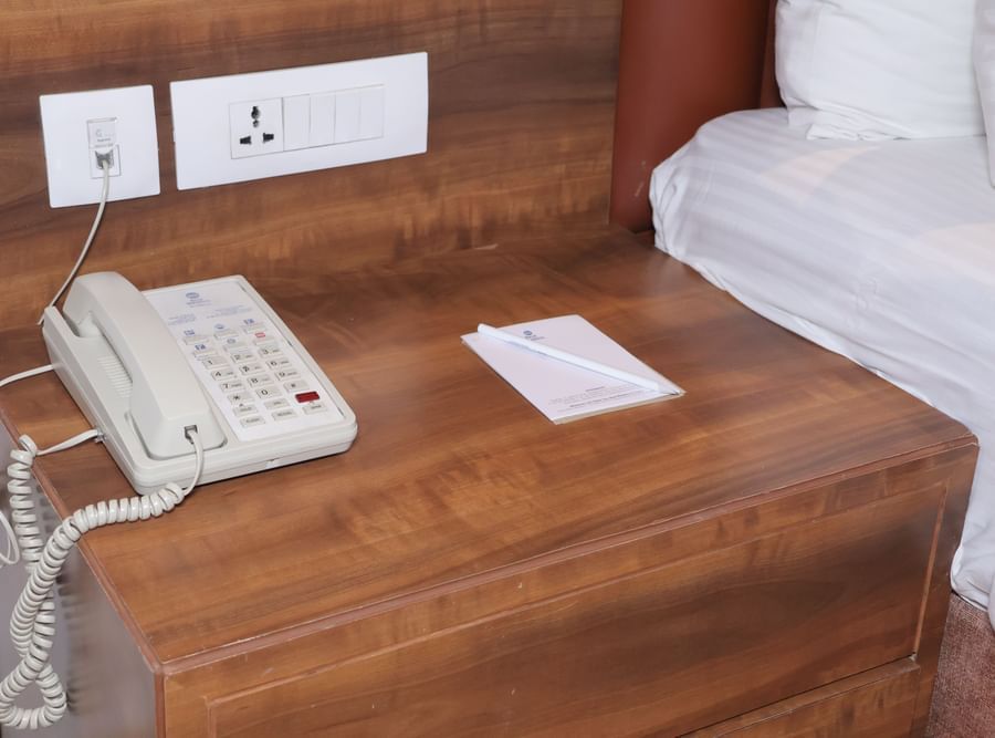 A landline phone on a wooden wall table at the Best Western, Vrindavan
