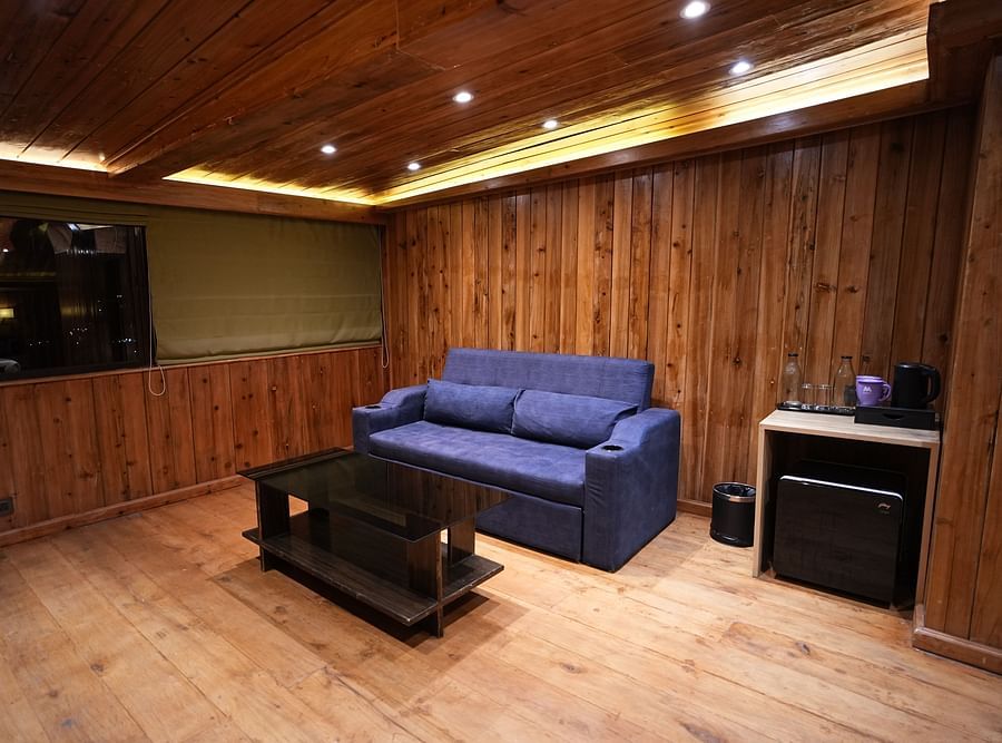 Spacious wooden room with a sofa, coffee table, and mountain view