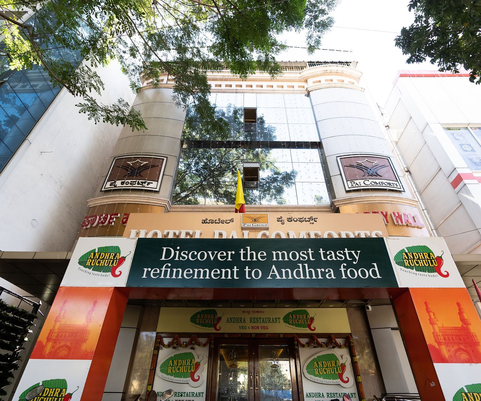facade image of Hotel Pai Comforts, JP Nagar with tree branches above