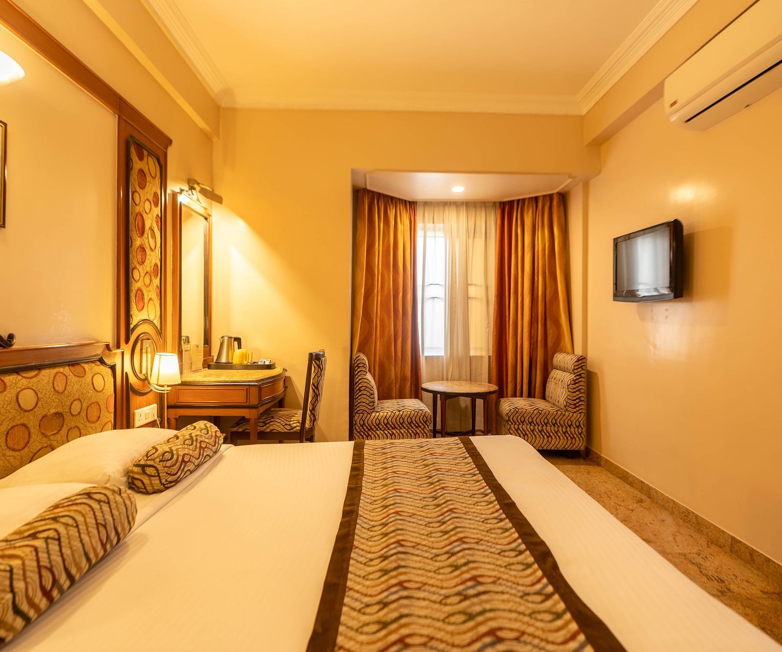 The Executive Room at Hotel Pai Viceroy Jayanagar featuring warm interiors and a queen sized bed amongst other amenities