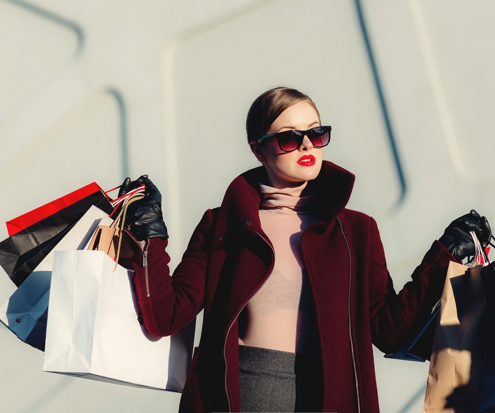 A girl posing for a picture while holding many shopping bags