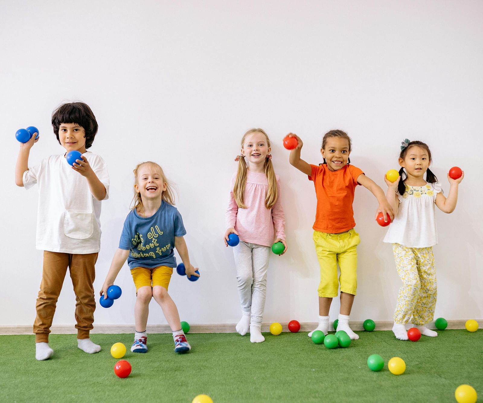 Image featuring a few kids playing with a lot of balls.