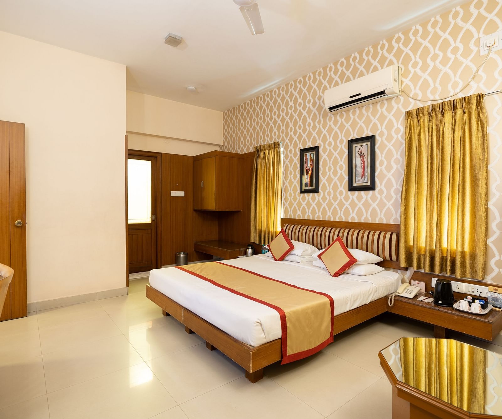 A double bed with a study table opposite it inside one of the rooms - Hotel Pai Vista, KR Road