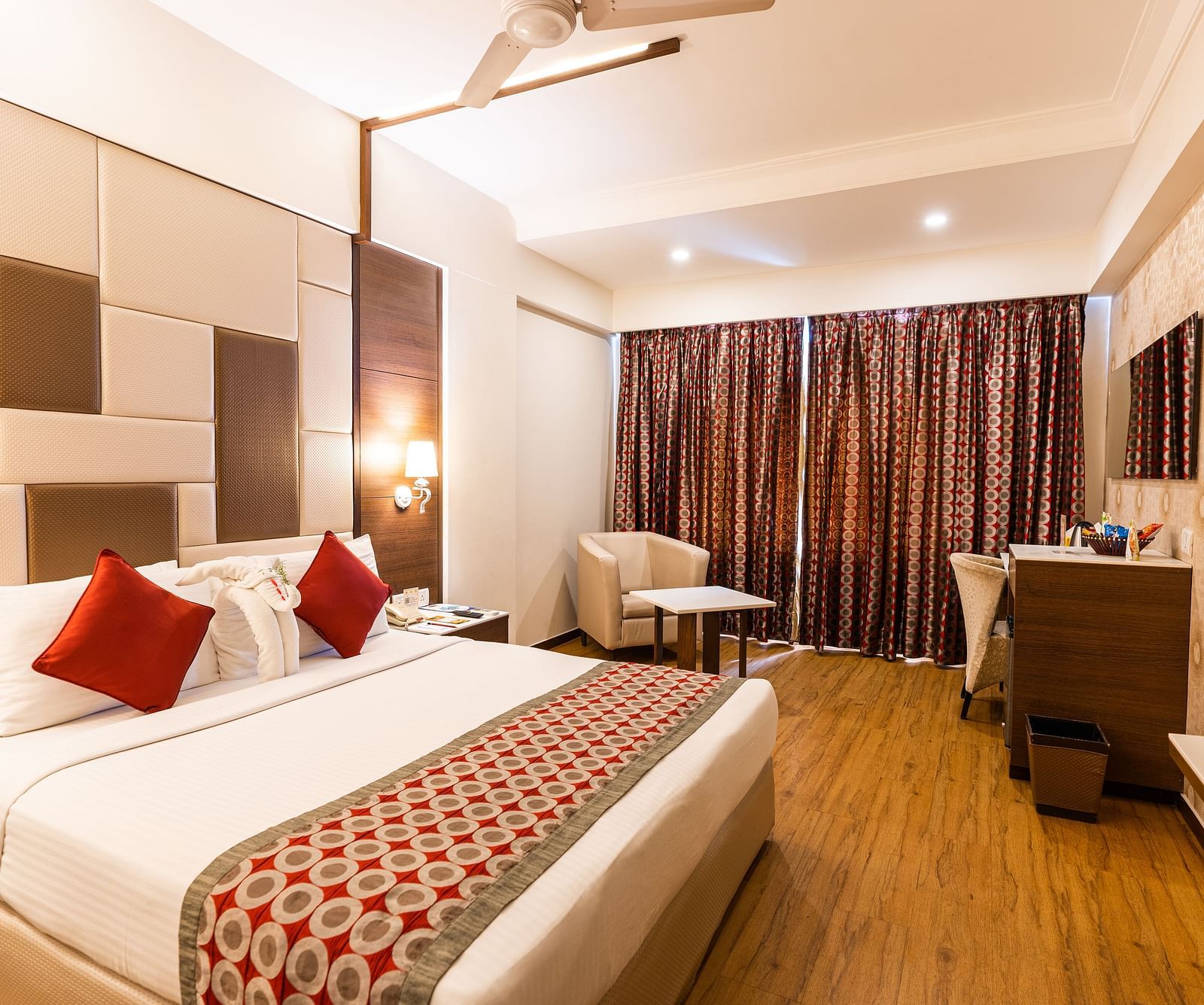 a double bed with red pillows and a runner kept on it inside one of the rooms - Hotel Pai Vista, Mysore