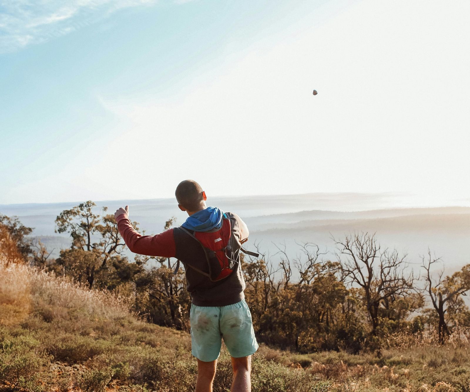 Image of a person standing, few plants in the background