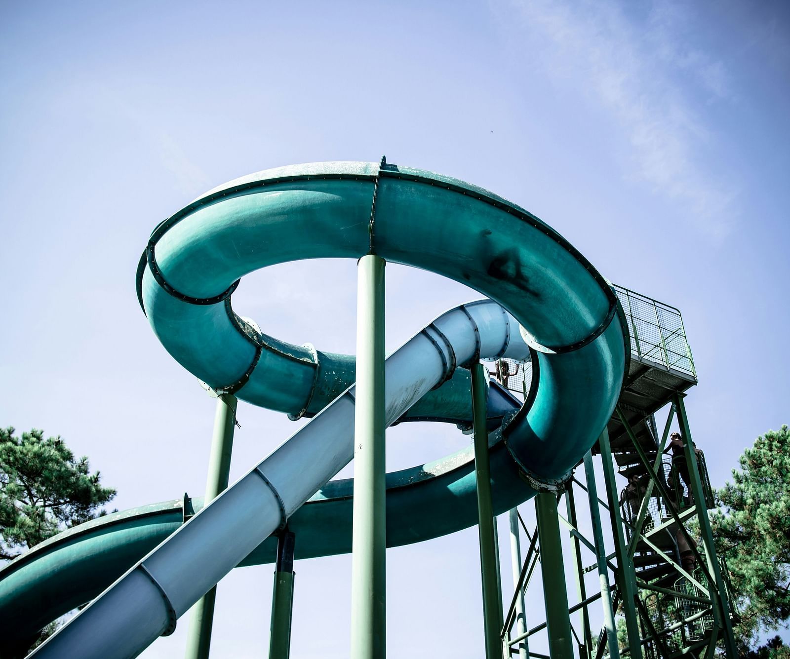 An overview of a ride in a waterpark with trees and blue sky in the background