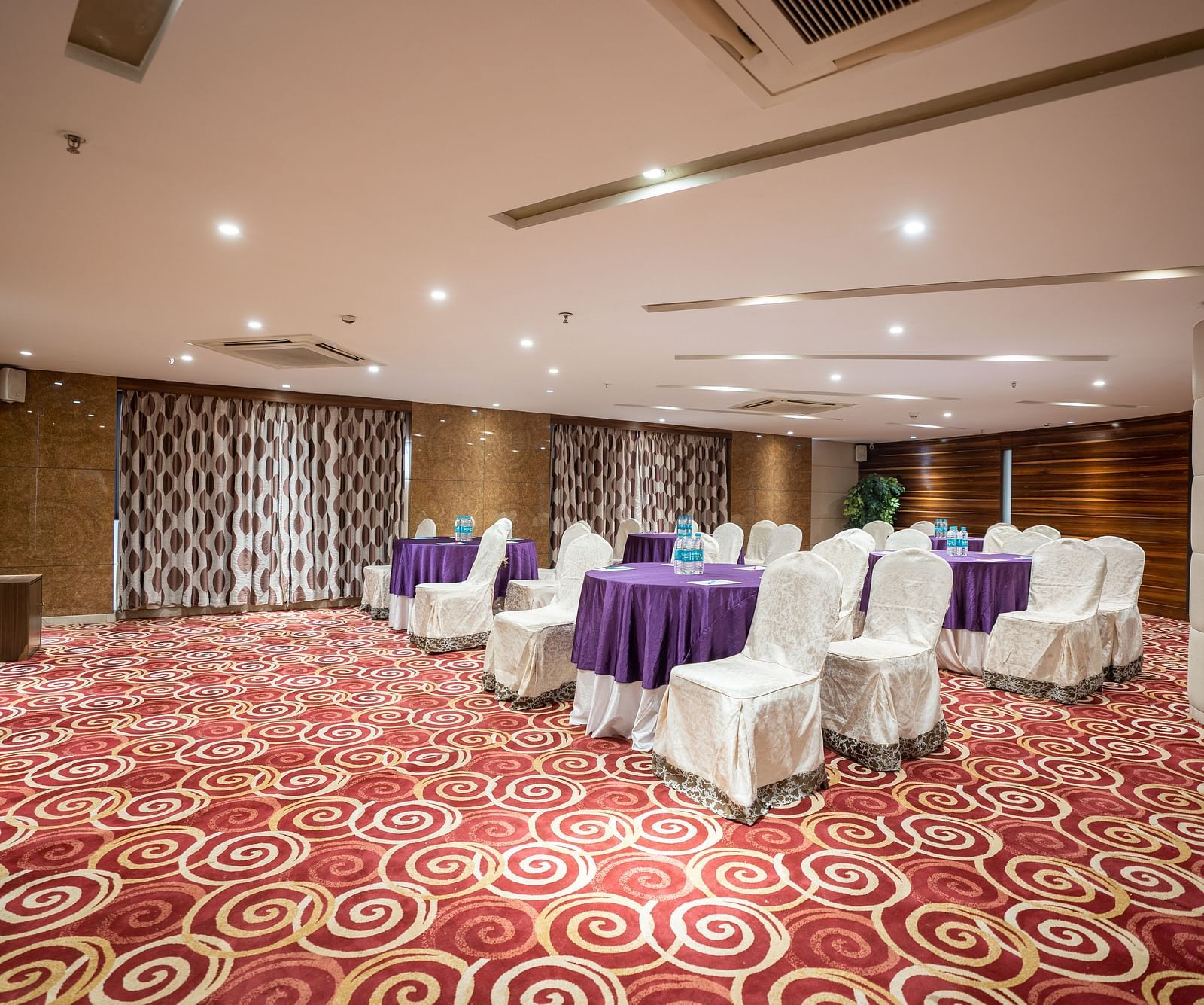 Seating arrangements inside Opal hall with light switched at The President Hotel, Hubli