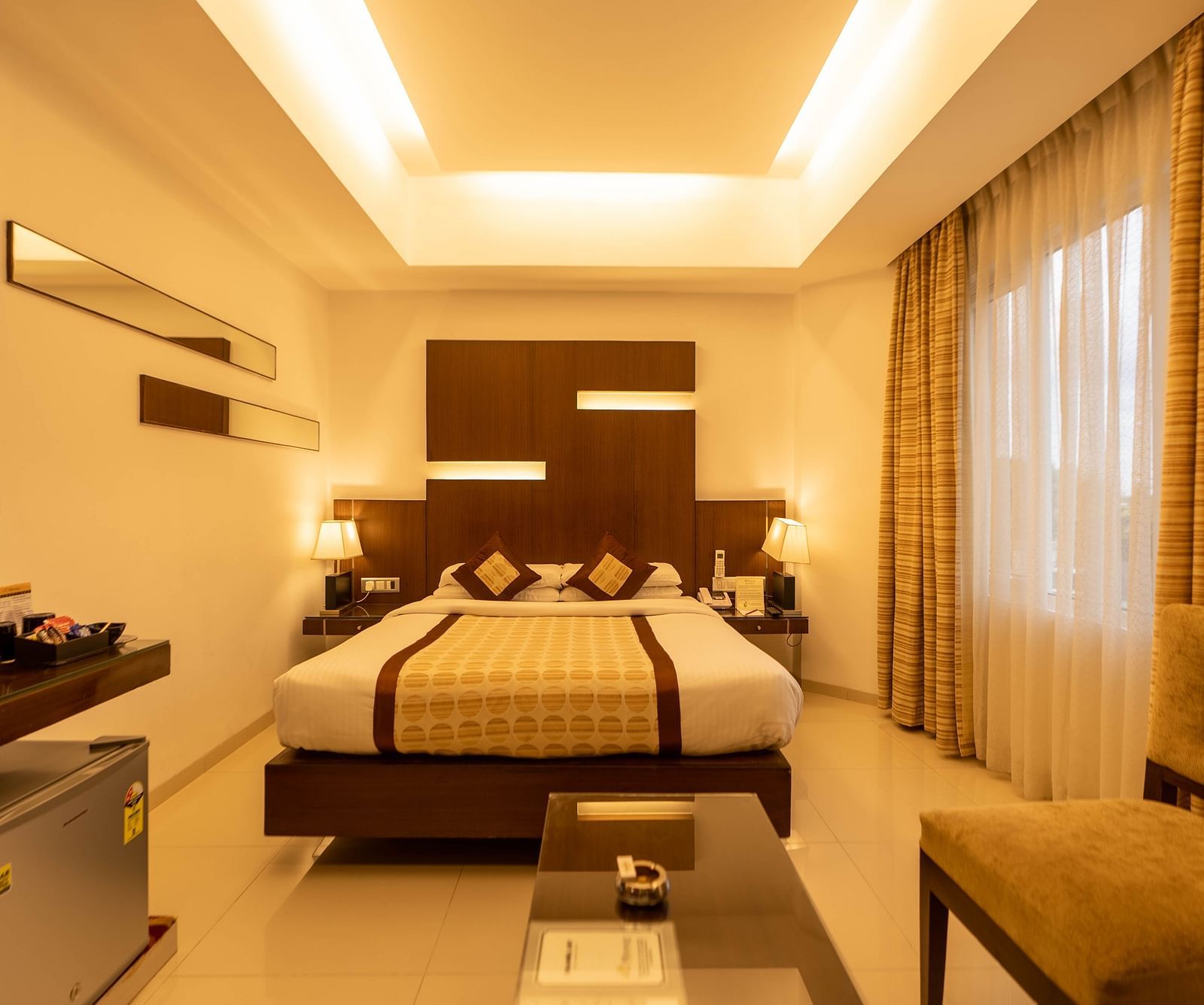 Modern and cosy hotel room with a spacious bed, seating area, sleek furnishings, and soothing lighting for a relaxing stay - The President Hotel Jayanagar, Bangalore