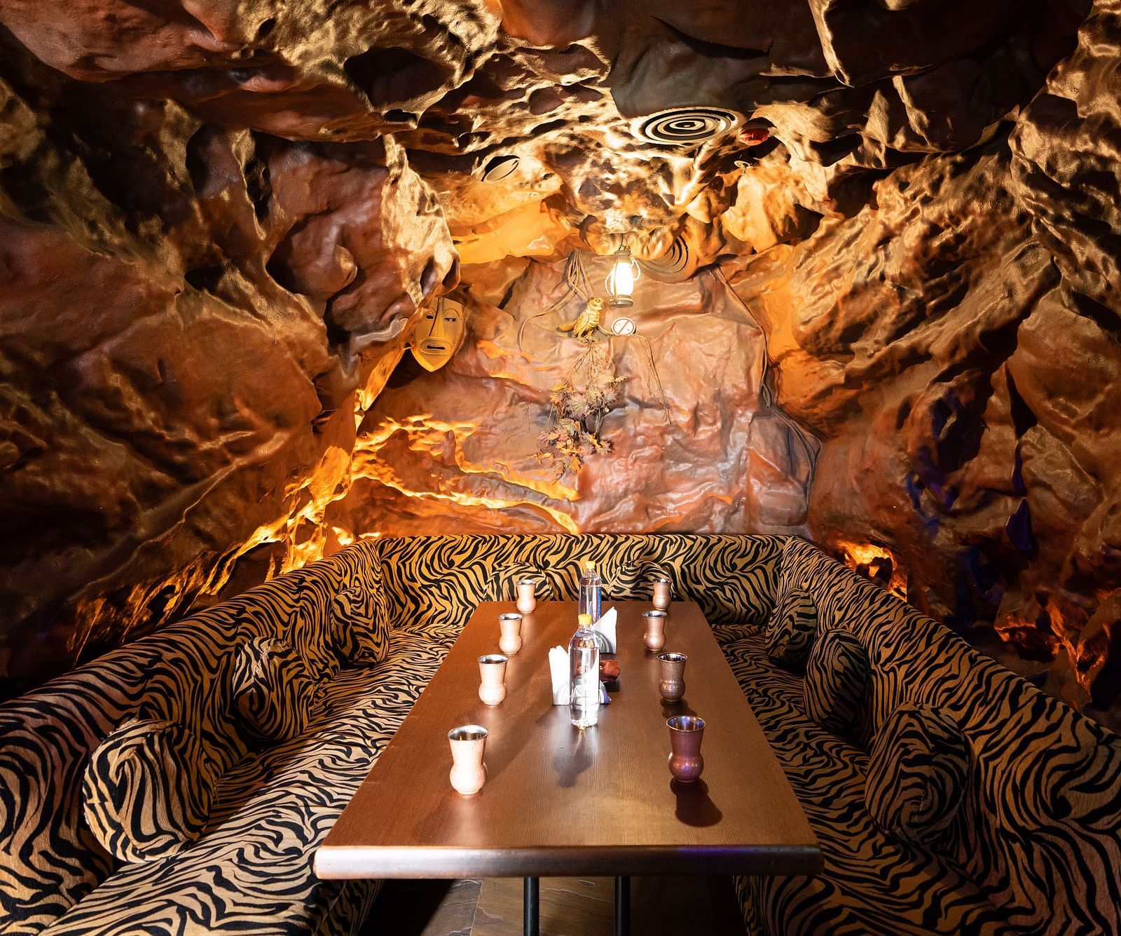 A unique restaurant with a cavernous atmosphere featuring a large Buddha face sculpture and textured walls, creating an immersive dining experience - The President Hotel Jayanagar, Bangalore