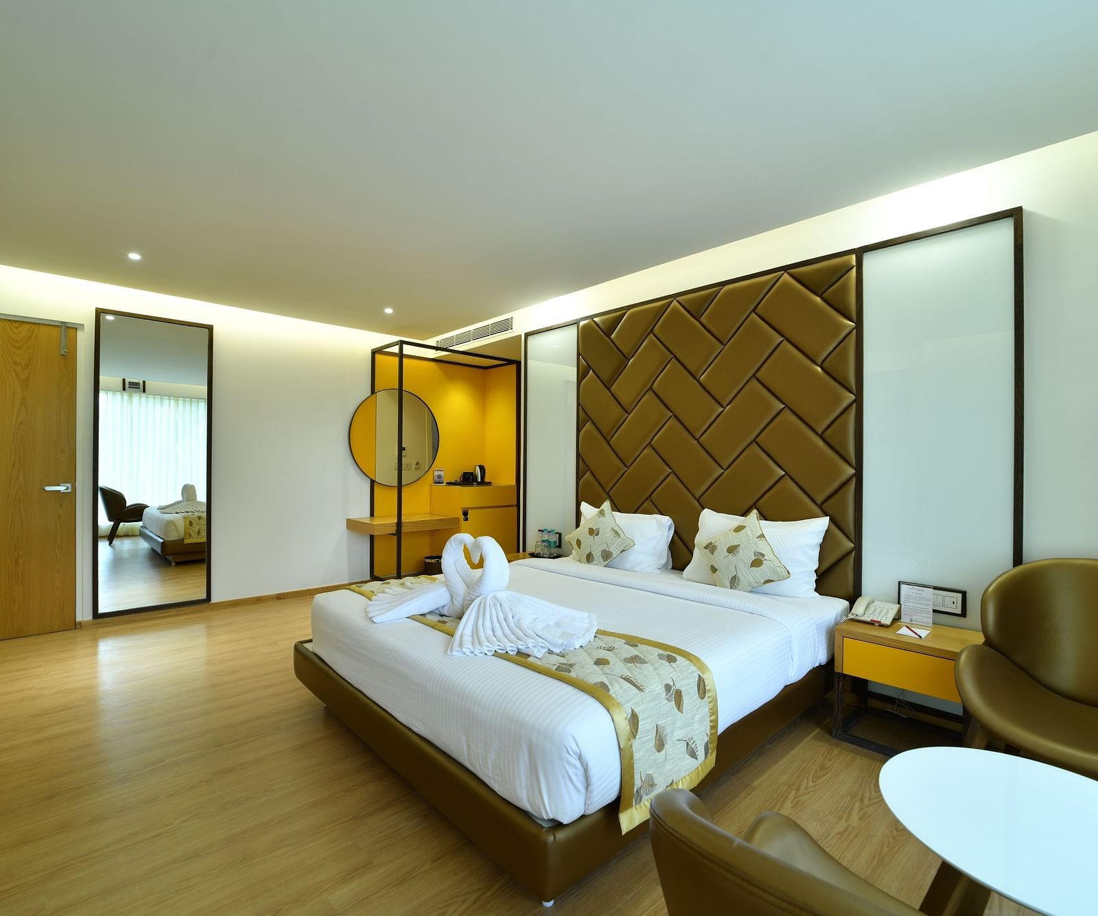 An image of a room with a bed and a golden yellow armchair -The President Hotel, Kumara Park, Bangalore