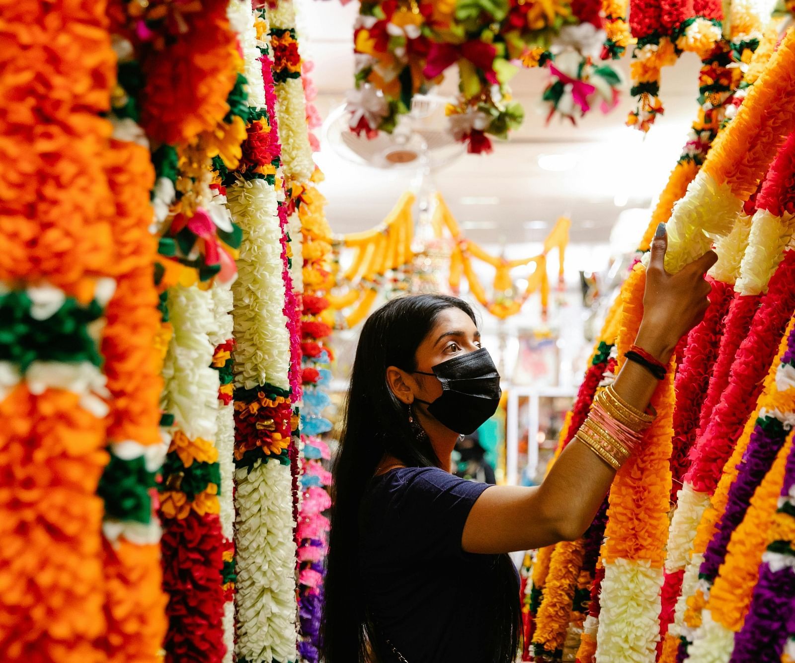 An image of a woman selecting flowers at a market.