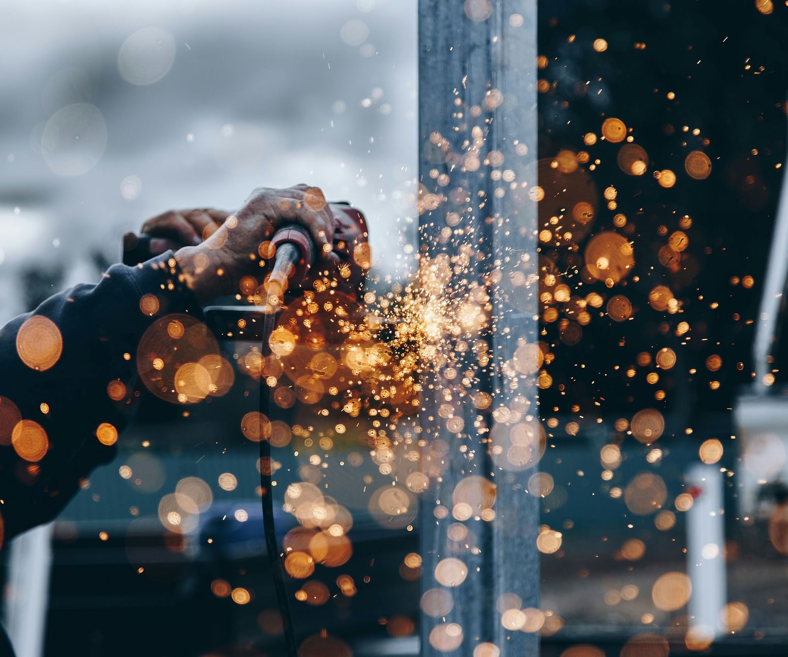 A person using a heavy machinery trying to tread an iron bar with sparks flying