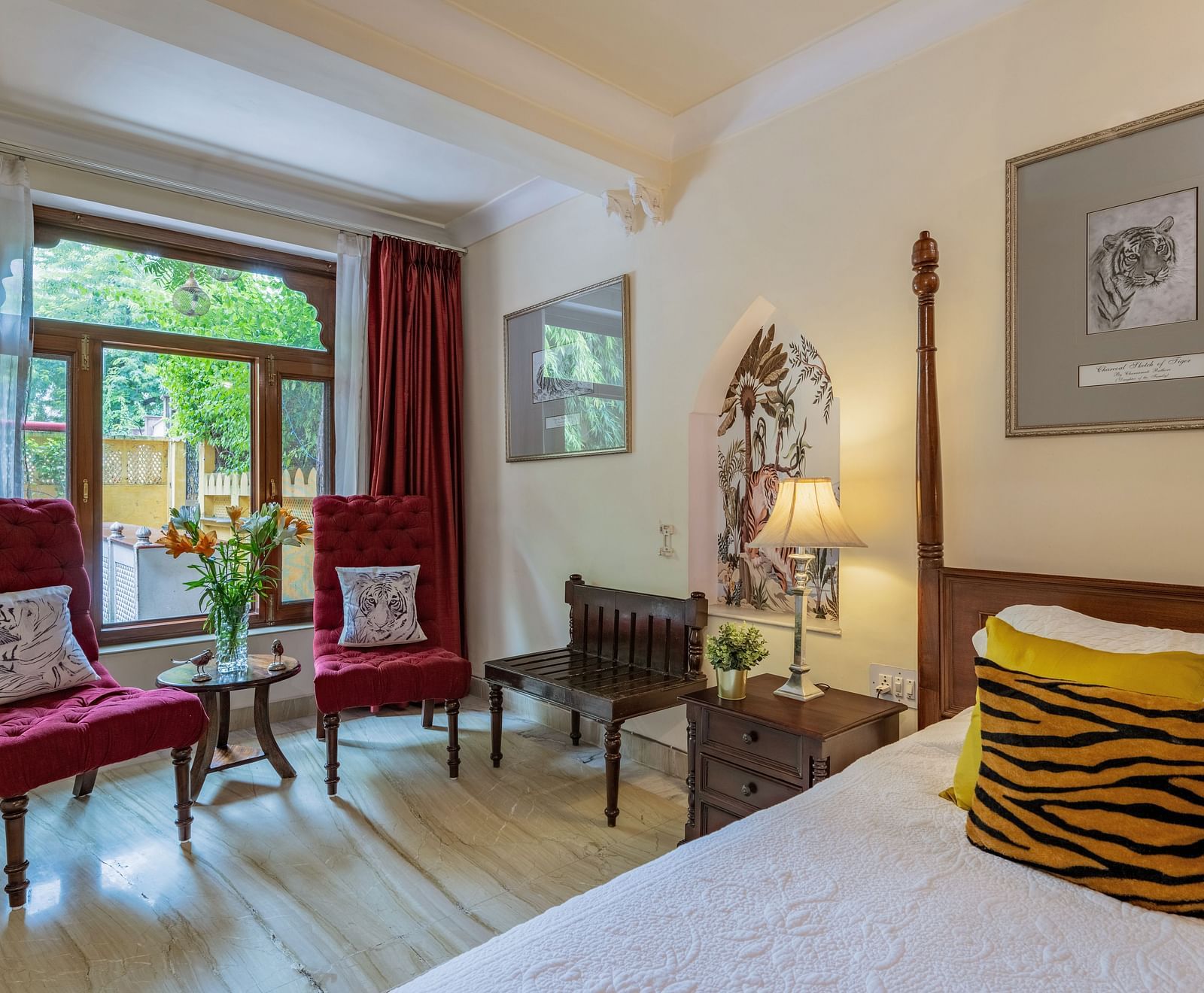A cozy room at Dera Rawatsar features a comfortable bed, two stylish armchairs by a window, and unique decorative elements.