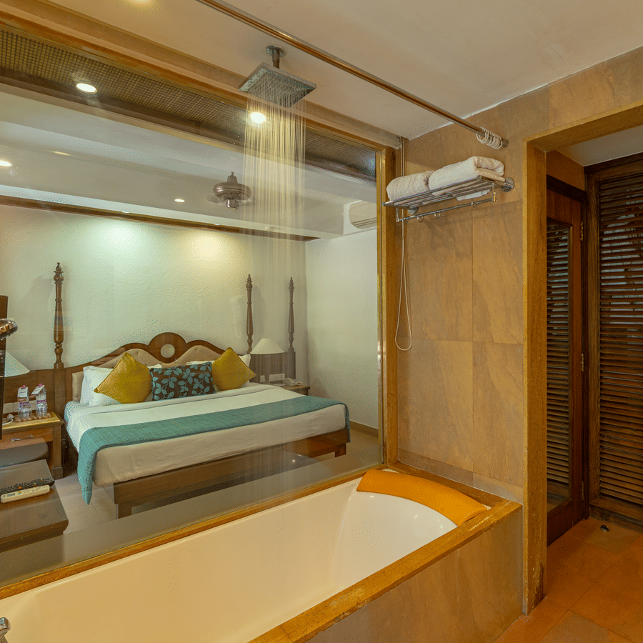 A view of a hotel room from inside of the bathroom with a bathtub.