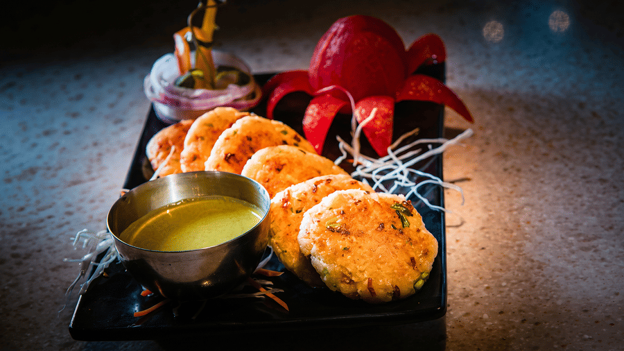 Golden pan-fried patties with green chutney, a tomato carved like a lotus and onion rings at Tandoori Tamashaa restaurant, Ilara Hotels & Spa, Tada.