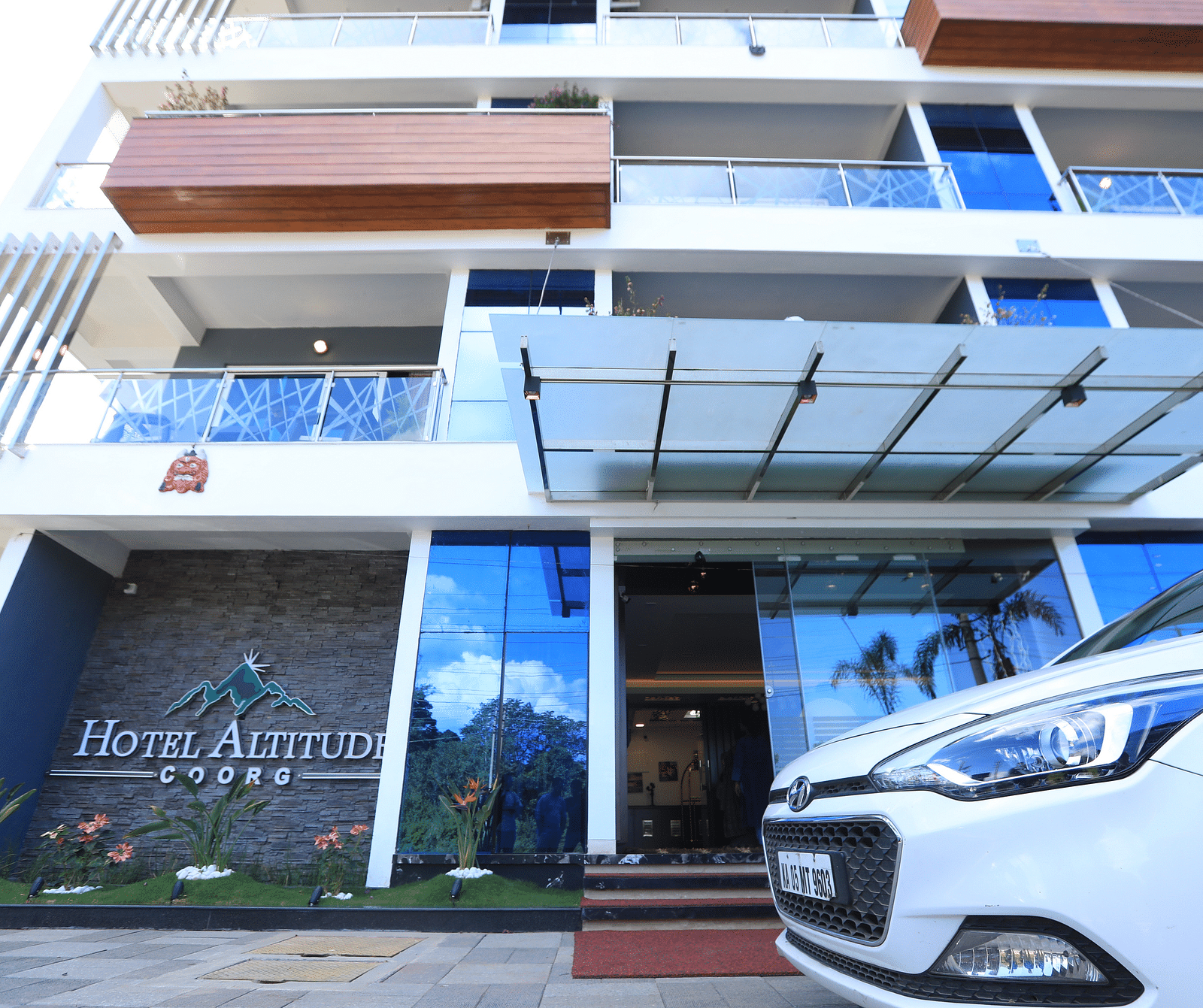 Facade of Hotel Altitude with a car parked in front of it.