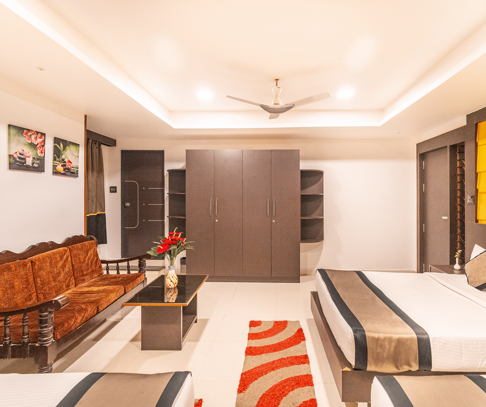 Image of a room with a bed and a sofa opposite to it at Parampara Residency, Kushalnagar Town.