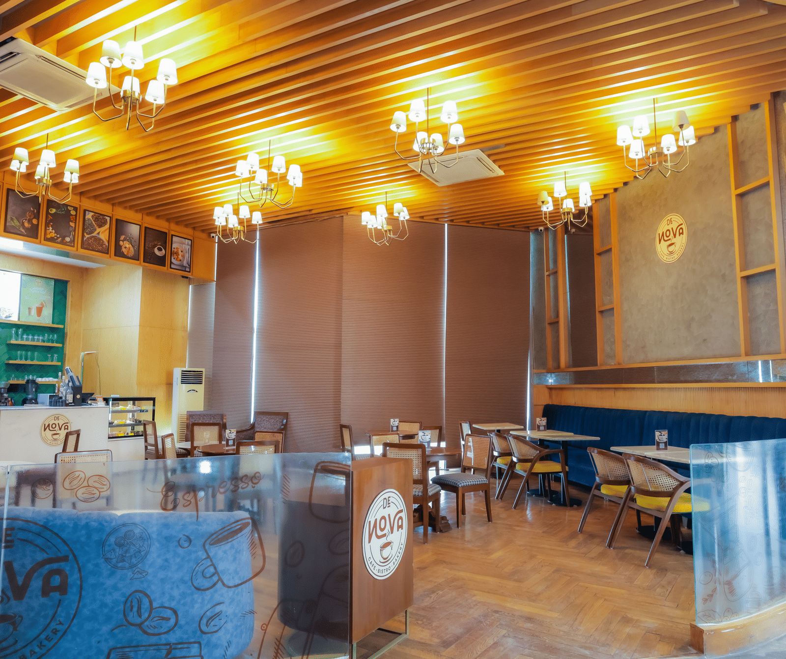 An elegant restaurant or dining area with warm lighting from chandeliers, tables set for dining, and a modern interior design.