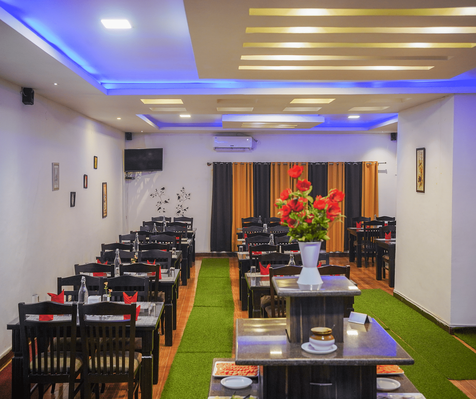 A dining space with tables and chairs and lights on the ceiling at Coorg Jungle Camp Backwater Resort, Kushalnagar.