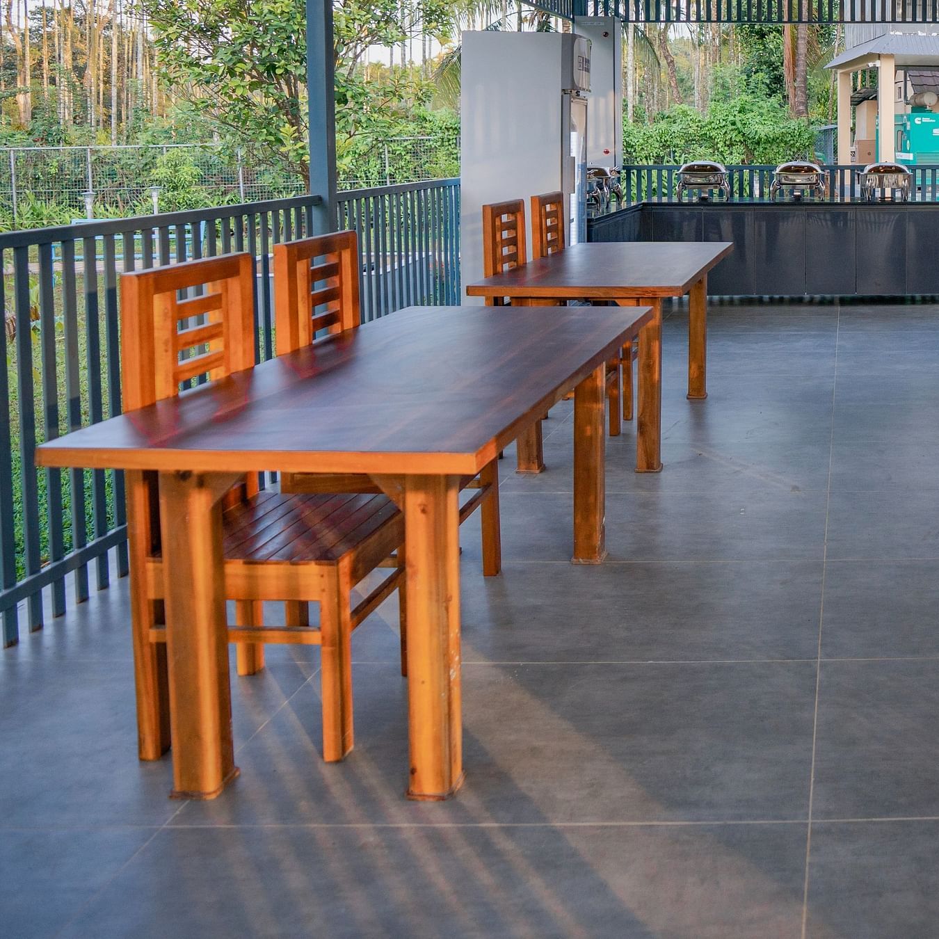Dining area with wooden tables and trees at Feel Free Retreat, Wayanad