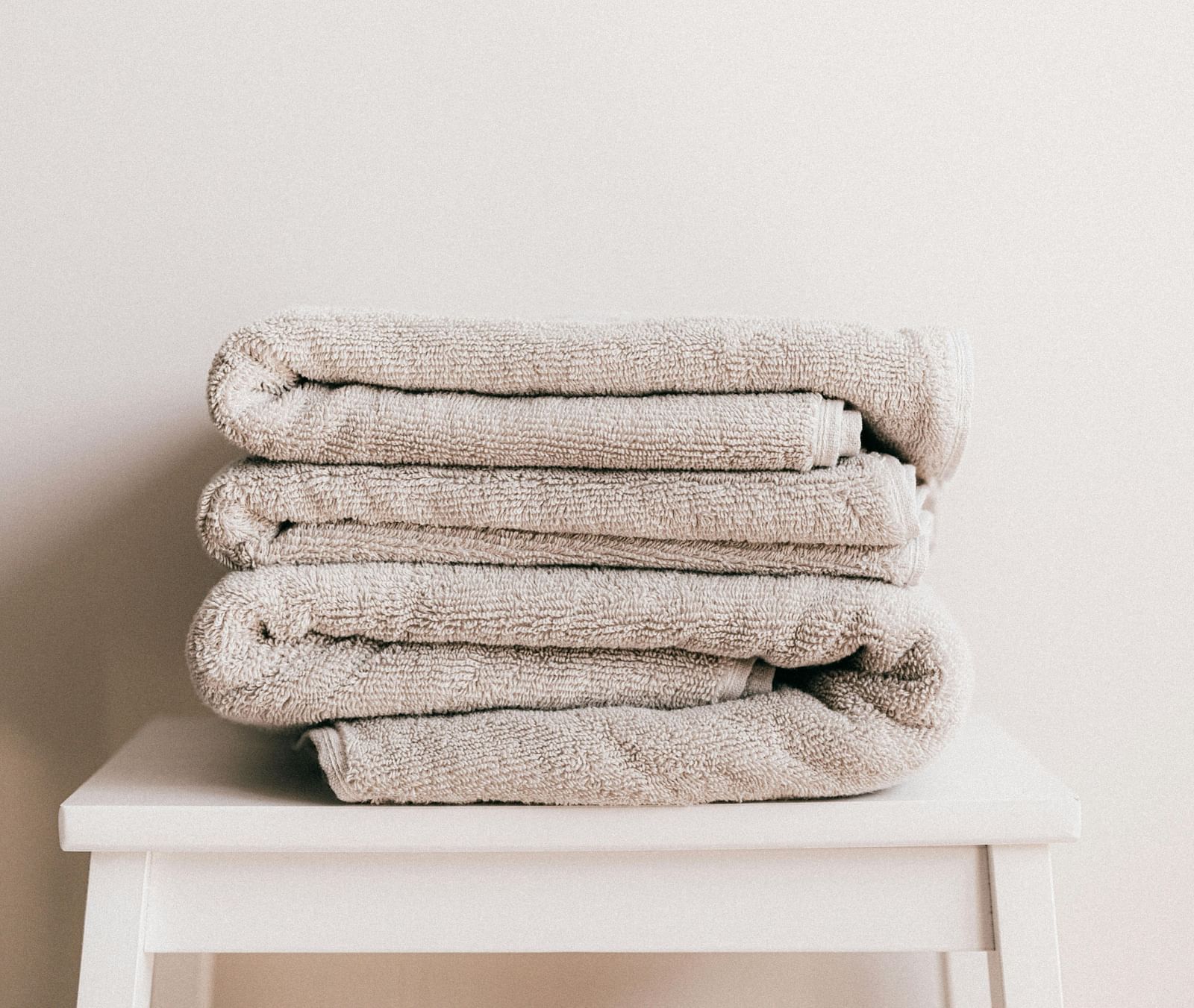 A few white towels neatly folded and kept on a stool.