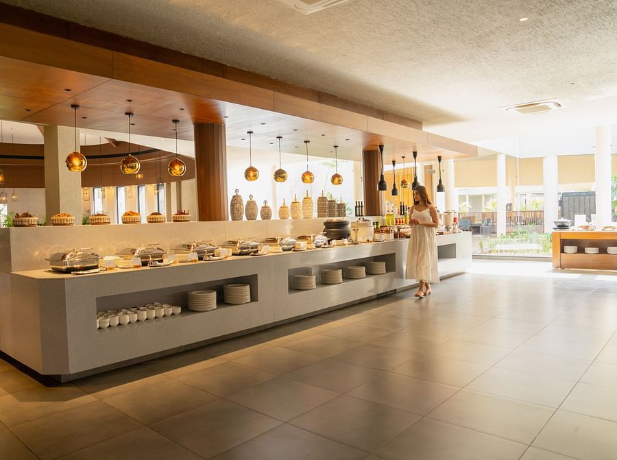 Woman walking through the buffet section of Annata Spa and Resort, Ajabgarh