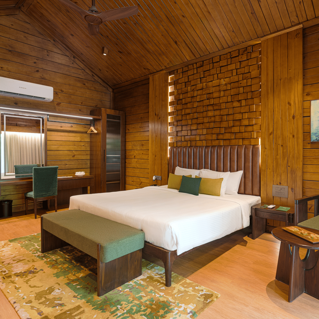 Premium Wooden Cottage with Bathtub bedroom with a bed, armchair and wooden ceiling at The Ananta Udaipur.