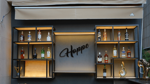 Another view shows Nemesia's outdoor bar area with shelves, a counter, and stools.